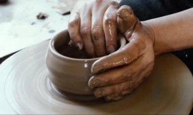 Çömlekçi çarkında çömlek aletleri olan kil ürünü, üst görünüm, ton sineması, el işi fabrikası otantik.