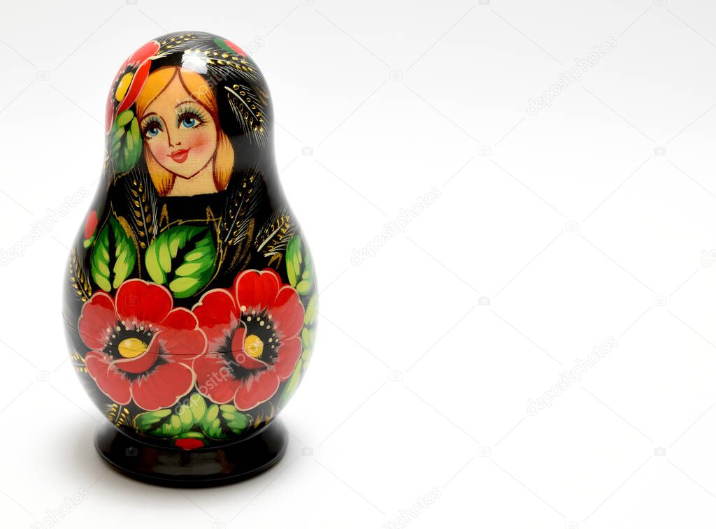 Assembled Russian nesting doll painted in black, red and green colors and isolated on white background.