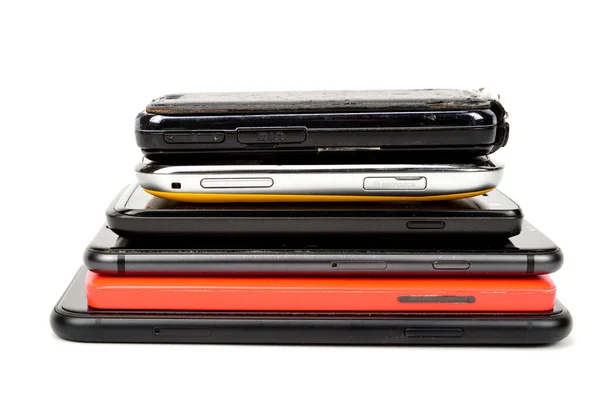 Akıllı telefonlar üst üste istiflenmiş ve beyaz arkaplanda izole edilmiş