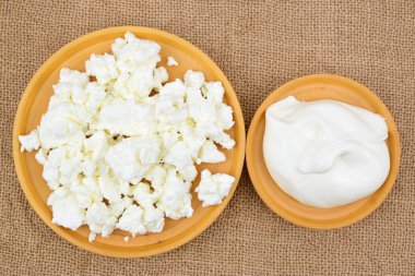 Süzme peynir ve ekşi krem bir hasırın üzerine serilmiş ahşap tabaklar