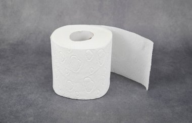 Ucu hafifçe açılmamış bir tuvalet kağıdı rulosu. Yuvarlak dikey olarak yerleştirilmiş. Gri arkaplanda izole.