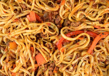 Kırmızı dolmalık biberli, havuçlu ve kıymalı udon eriştesi. Tabak teriyaki sosuyla dolduruldu..