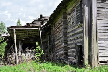 Harap olmuş bir kulübenin duvarı. Harap olmuş kütükler, çökmüş bir veranda. Bir kara delikle durağan boşlukların girişi..