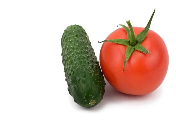 一只新鲜的绿色黄瓜和一只红色的西红柿肩并肩地躺着 投下了一个小小的阴影 因白人背景而被隔离 — 图库照片