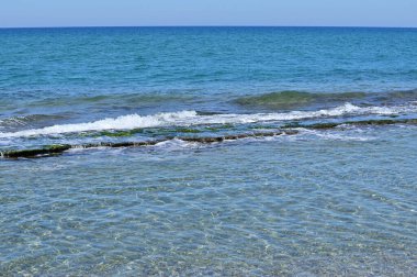Deniz sörfü su altında doğal bir taş levhanın üzerinde yuvarlanıyor. Deniz ufku.