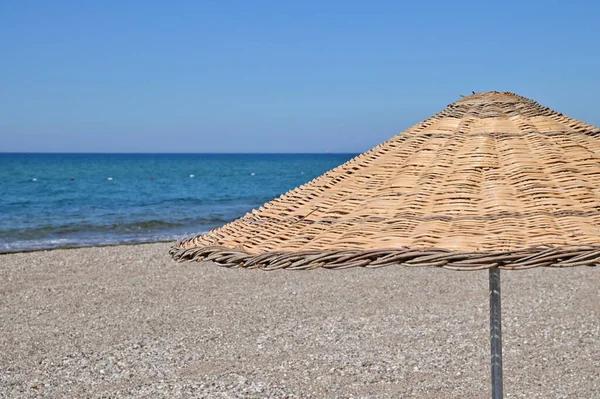 Reed Umbrella Pebble Beach Mediterranean Coast Blue Sea Background — Stock Photo, Image