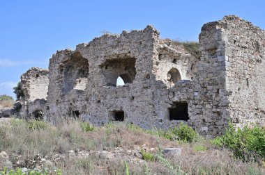 Gri tuğlalardan inşa edilmiş eski bir Roma hastanesinin iki katlı terk edilmiş binasının yan görüntüsü..