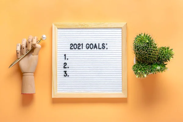 Text - 2021 goals Motivational quote on message felt board, wooden hand, cactus on yellow background Planning, self motivation, achievement, success, wish list, checklist concept Top view Flat lay — Stock Photo, Image