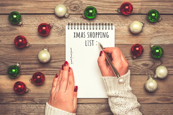 Female Hand Holds Pen Writing Christmas Shopping List Gift Ideas — Stock Photo, Image