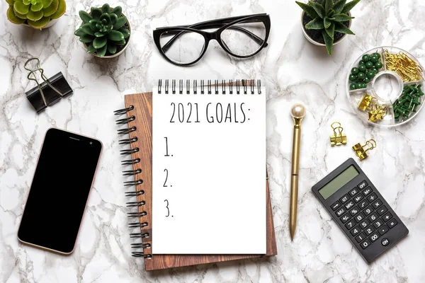 Open notepad text Goals 2021, glasses, cup of coffee, pen, smartphone, succulents on marble table Top view Flat lay Education, resolutions, plan, small owner business concept Home workplace — Stock Photo, Image