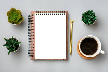 açık not defteri, kahve fincanı, sulandırıcılar, gri arka planda altın kalem, masa üzerinde spiral defter iş, planlama, eğitim, ev konsepti Top view düz yatay çalışma