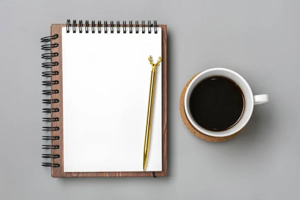 açık not defteri, kahve fincanı, sulandırıcılar, gri arka planda altın kalem, masa üzerinde spiral defter iş, planlama, eğitim, ev konsepti Top view düz yatay çalışma