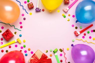 İçinde çeşitli parti konfetileri, balonlar, flamalar, pokerler ve pembe arka planda süslemeler olan renkli bir parti çerçevesi. Tatil kartı düz yatıyordu Üst görünüm Mutlu yıllar parti konsepti.