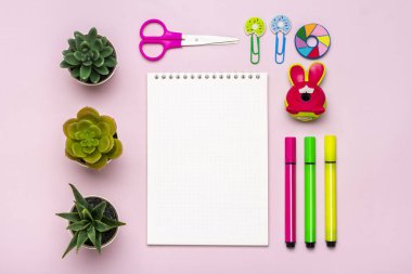 Kırtasiye, okula dönüş, yaz zamanı, yaratıcılık ve eğitim konsepti okul malzemeleri - büyüteç, kalem, ataç, zımba ve not defteri pembe arka planda, düz yatay