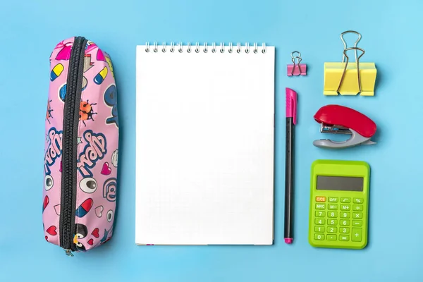 Stationair, terug naar school, zomer tijd, creativiteit en onderwijs concept Schoolbenodigdheden - vergrootglas, rekenmachine, potloden, pen, paperclips, nietmachine en notitieblok op blauwe achtergrond, plat lay Mock up — Stockfoto