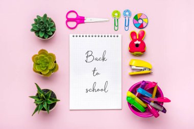 Kırtasiye, okula dönüş, yaz zamanı, yaratıcılık ve eğitim konsepti okul malzemeleri - büyüteç, kalem, ataç, zımba ve not defteri pembe arka planda, düz yatay