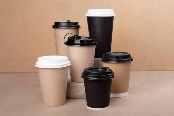 Un montón de tazas de café de papel para beber en el fondo de cartón — Foto de Stock