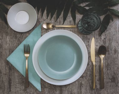 Yukarıdan güzel bir masa. Masada boş tabak ve çatal bıçak takımı.