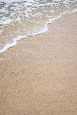 Metnin için fotokopi alanı olan kumlu sahilde el salla, yüksek açılı arka plan.