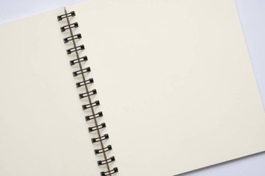 Üst görünüm, beyaz arkaplanda boş spiral defter aç, metin için boşluk kopyala.