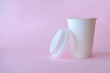 Pembe arka planda kağıt kahve fincanı, kahve fincanı maketi, metin için kopyalama alanı.