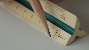 Yaklaş, Erkek Eller, Beyaz Kağıt üzerinde Tahta Kalem ve Çizim Aletleri ile Üçgen Ölçeklendirici Cetvel Kullan.