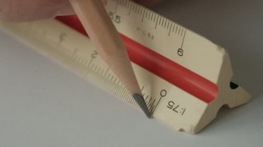 Yaklaş, Erkek Eller, Beyaz Kağıt üzerinde Tahta Kalem ve Çizim Aletleri ile Üçgen Ölçeklendirici Cetvel Kullan.