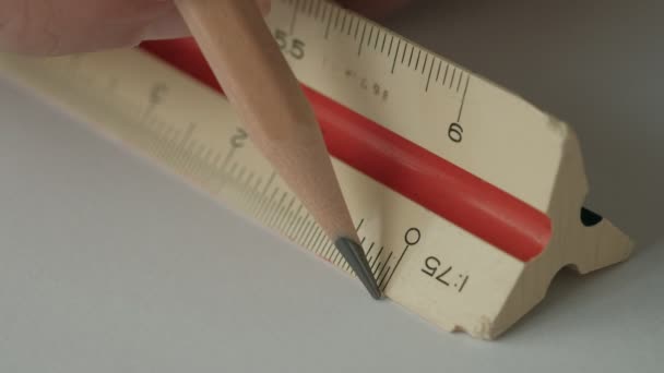 男性手使用三角形刻度尺 白色纸上有木制铅笔 绘图工具 — 图库视频影像