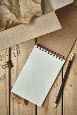 Boş Karton Kutu ile Boş Spiral Defteri Aç ve Tahta Masa üzerinde Kara Kalem, Çevrimiçi Alışveriş Düz Yatay Konsepti, Metin için Boşluğu Kopyala.