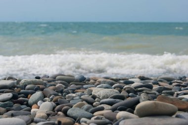 Denizde üç ya da dört noktalı küçük bir fırtına, dalga kıyıya büyük bir çakıl taşıyla vurur. Karadeniz, yaz tatili plaj seyahati
