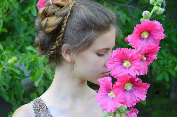 Ragazza con acconciatura e rosa hollyhocks — Foto Stock