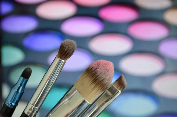 Pędzle do makijażu na tle palety z eyeshadow — Zdjęcie stockowe
