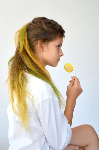 Chica con hebras de colores y con una piruleta —  Fotos de Stock