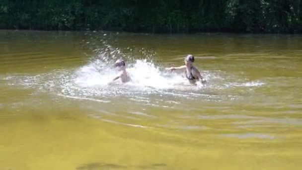 Boy and girl splashing in the river — Stock Video