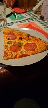 Salamlı ve erimiş peynirli pizza dilimleri.