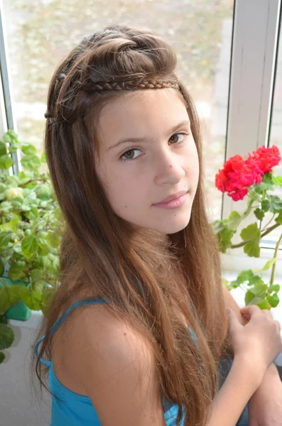 Fata lângă fereastră cu geranium — Fotografie, imagine de stoc