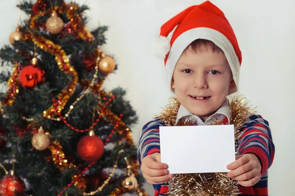 Chico sosteniendo la tarjeta de felicitación. Navidad. — Foto de Stock