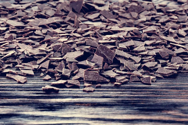 Flocos de chocolate escuro em uma mesa de madeira — Fotografia de Stock