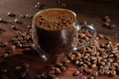 Sıcak kahve ve kahve çekirdekleri eski ahşap masada.