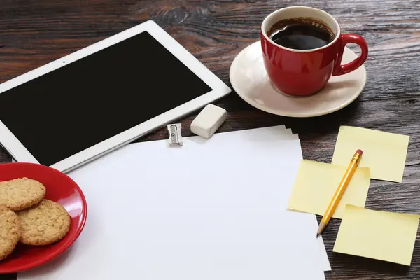 Taza de café y tableta en mesa de madera — Foto de Stock