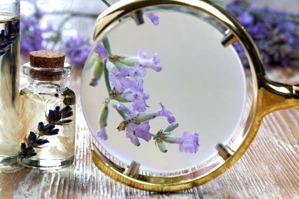 Weißes Herz und Lavendelöl auf Holztisch — Stockfoto