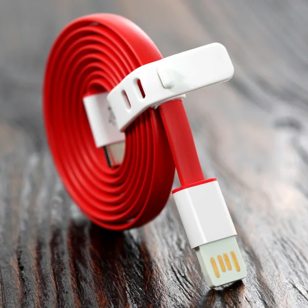 Cabo USB vermelho na mesa de madeira — Fotografia de Stock