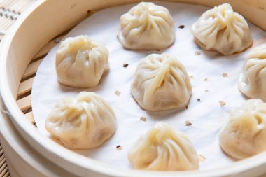 Buharda pişirilmiş Xiaolongbao geleneksel buhar sepetinde servis edilir.