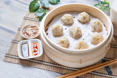 Buharda pişirilmiş Xiaolongbao geleneksel buhar sepetinde servis edilir.
