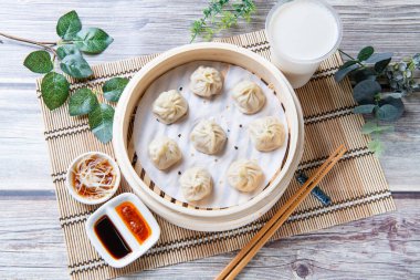 Buharda pişirilmiş Xiaolongbao geleneksel buhar sepetinde servis edilir.