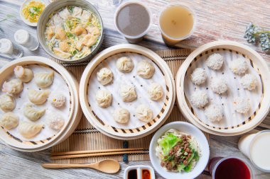 Buharda pişirilmiş xiaolongbao ve buharda pişirilmiş hamur köfteleri geleneksel bir buhar sepetinde servis edilir. 