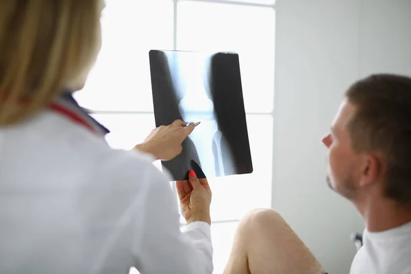 Dokter en patiënt kijken naar röntgenfoto 's. — Stockfoto