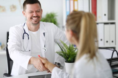 Doktorlar ofiste gülümseyip el sıkışıyorlar..