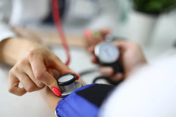 Arzt misst Blutdruck seiner Patienten beim Termin. — Stockfoto