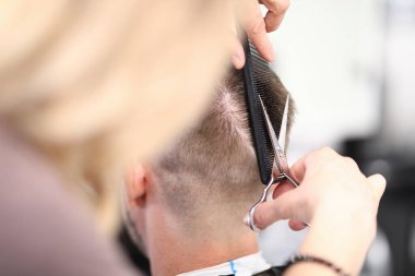 Usta adamı makas ve tarak ile keser..